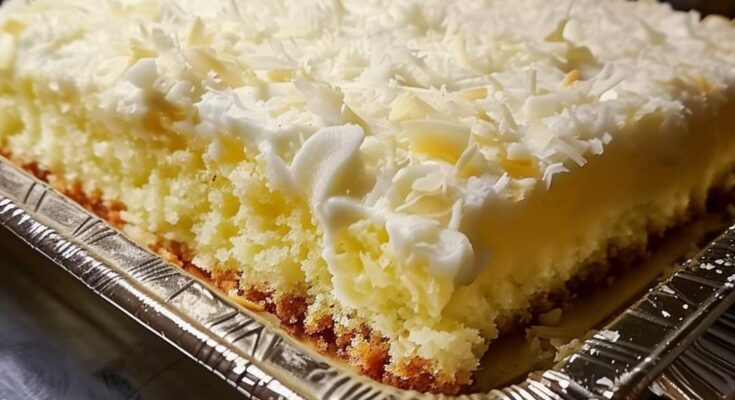 Soft white cake soaked in cream of coconut and topped with Cool Whip and shredded coconut